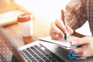 Image shows a dental practice owner writing in a notebook to strategize how to grow their practice.